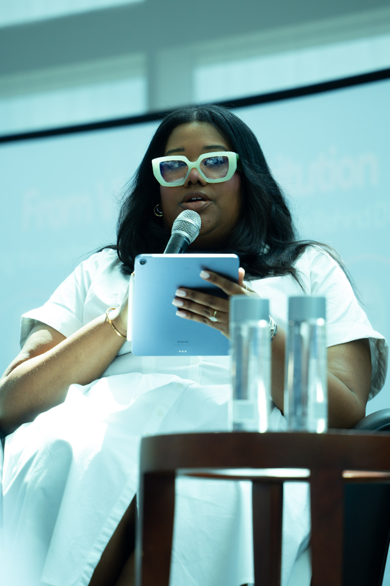 Panelist speaking with a microphone and tablet