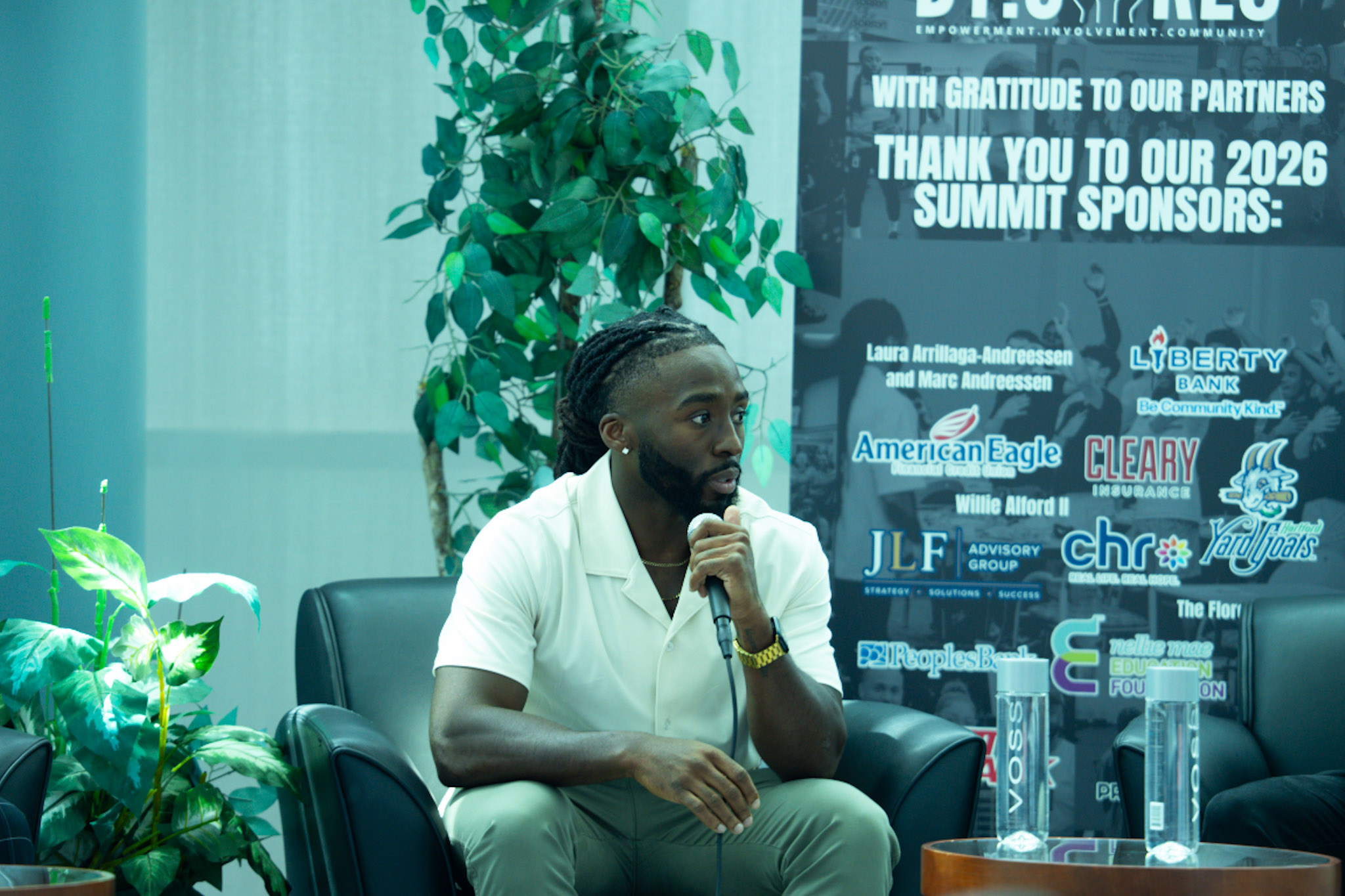 Speaker sharing his story in front of the sponsor banner