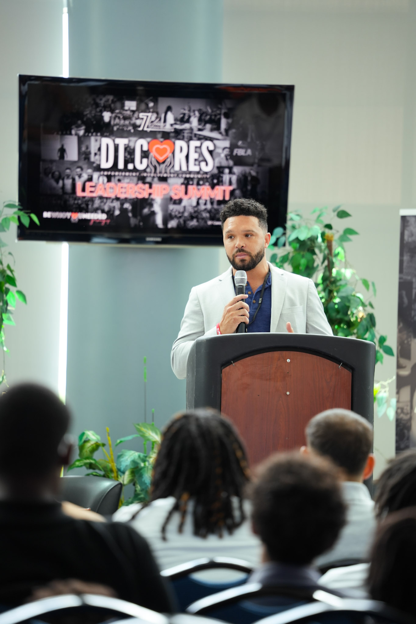 Host welcoming the room under the Leadership Summit screen